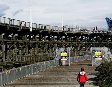 Landscape photograph of Dunston Staiths, an industrial wooden structure, with wooden decking in the foreground and the temporary walkway can be seen in the background on the right hand side. 