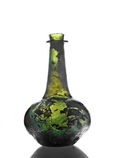 A cracked but intact green glass bottle, with unspecified residue inside.