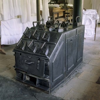 A solid fuel stove heating irons in the dry laundry