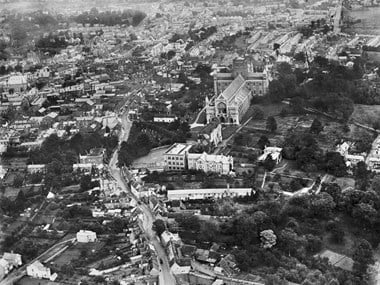 A view of St Albans Cathedral in 1920. In the foreground is a long narrow building - one of the towns' 