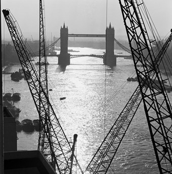 Archive photograph of Tower Bridge in the mist viewed from riverside gantries, looking east along the River Thames