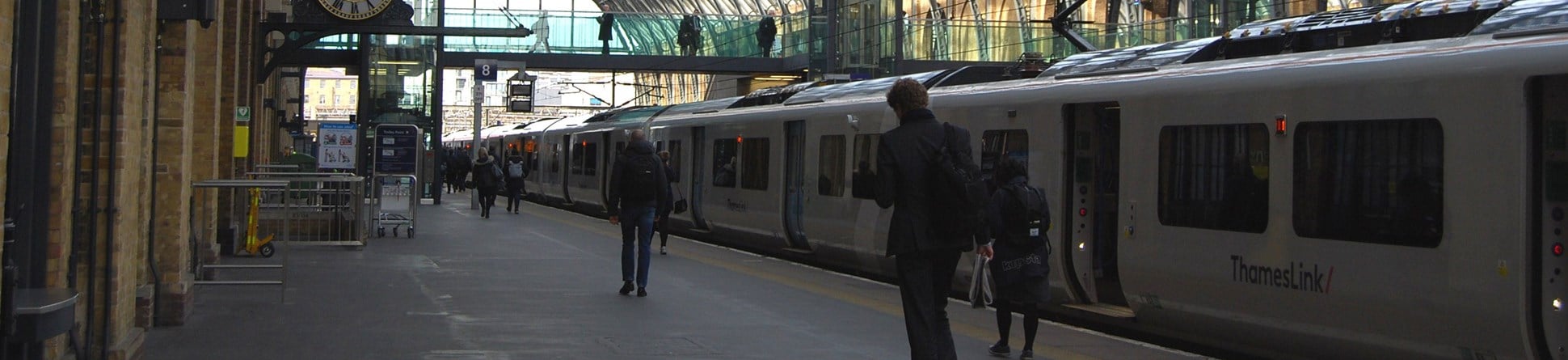 Passengers walking along a platform at King's Cross Station