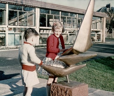 Two children touching the sculpture