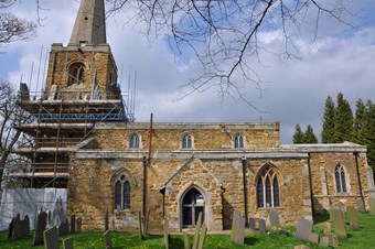Church of St James the Greater with bell tower partially covered by scaffolding