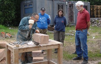Stone shaping tutor with volunteers