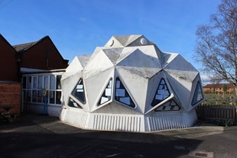 Exterior of a domed building created out of triangular panels, each group of three panels protude like a pyramid