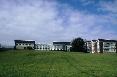 Exterior photo of a school building with its playing field in the foreground