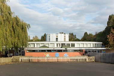 photo of a school building with trees behind and to either side.