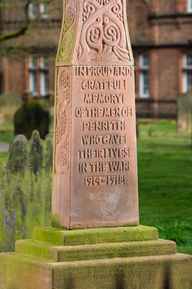 Image of Penrith War Memorial at St Andrew’s, Penrith, Cumbria, newly listed at Grade II. A tall and stately cross made from warm, red sandstone commemorates the 165 men and one woman from Penrith who died during the First World War. Included among the names are members of The Lonsdales, recruited in Penrith, who died on the first day of the Battle of the Somme. 