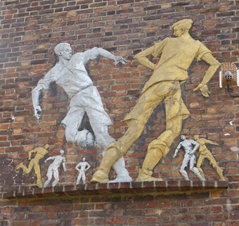 Relief of Boys Playing Football by Peter Laszlo Peri, 1951-2. Wareham House, South Lambeth Estate, Fentiman Road, London. Listed Grade II © Historic England