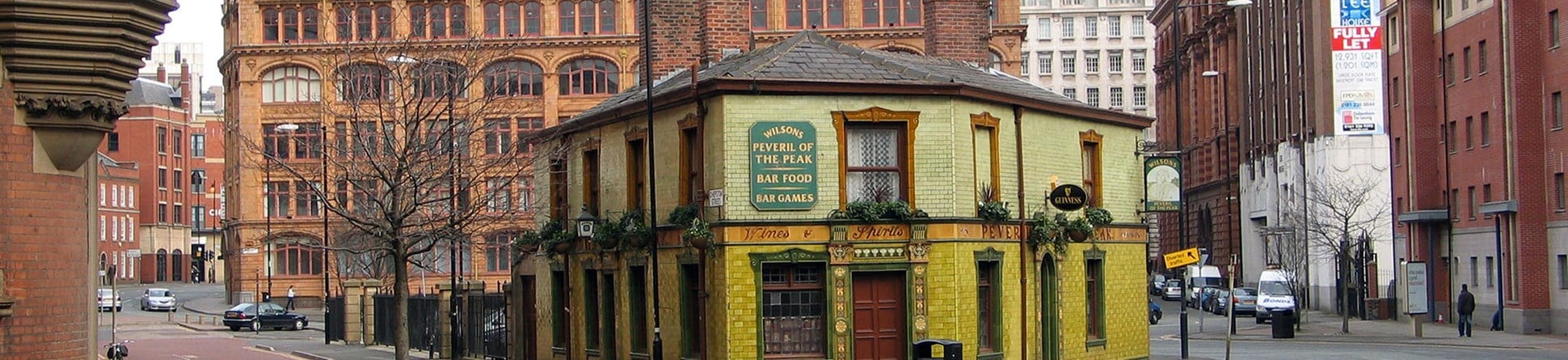 Exterior photo of the green tiled front of the Peveril of the Peak pub.