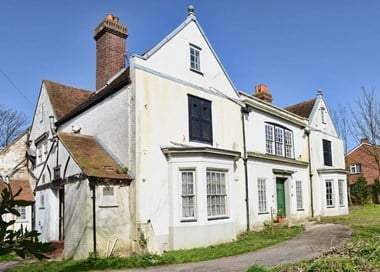 Image of Wymering Manor, the white building looks a bit bedraggled as it is on the Heritage At Risk Register.