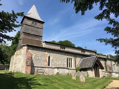 View of the church made of stone with a tower clad in wood