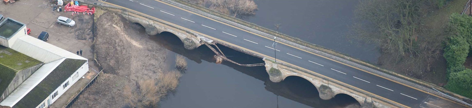 Aerial photograph of a damaged historic bridge.