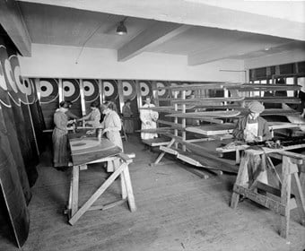 Waring and Gillow’s factory, Hammersmith, London, 1916 Women and boys painting the wings of bi-planes. The roundels of the Royal Flying Corps are drying on the walls. (BL23701/012)