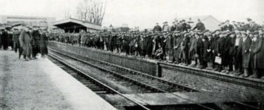Codford station, Wiltshire. This image conveys the remarkable changes brought about at little country stations which were originally constructed to serve only a small number of passengers and which, during the war, were over-flowing with workers. The men pictured here waiting for a workmen’s train were employed erecting huts for military camps on nearby Salisbury Plain. (Pratt 1921 'British Railways in the Great War') 