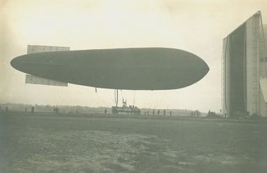 First World War airship. Airship being manoeuvred into its shed, probably at Farnborough, Hampshire. This picture illustrates the large number of personnel required to handle airships. Private Collection