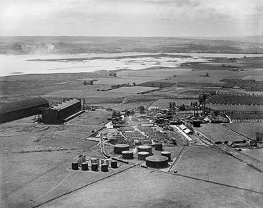 Royal Naval Air Service airship station, Kingsnorth, Medway. The station was established just before the outbreak of war, this image shows two airship hangars to the left and traces of a camp to the centre which housed the station’s personnel. The site was later developed as an oil refinery whose storage tanks are in the foreground.