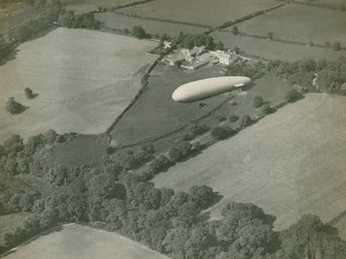 Sea Scout airship over the English countryside. The type of airship would have patrolled the coast hunting for U-boats. Private Collection