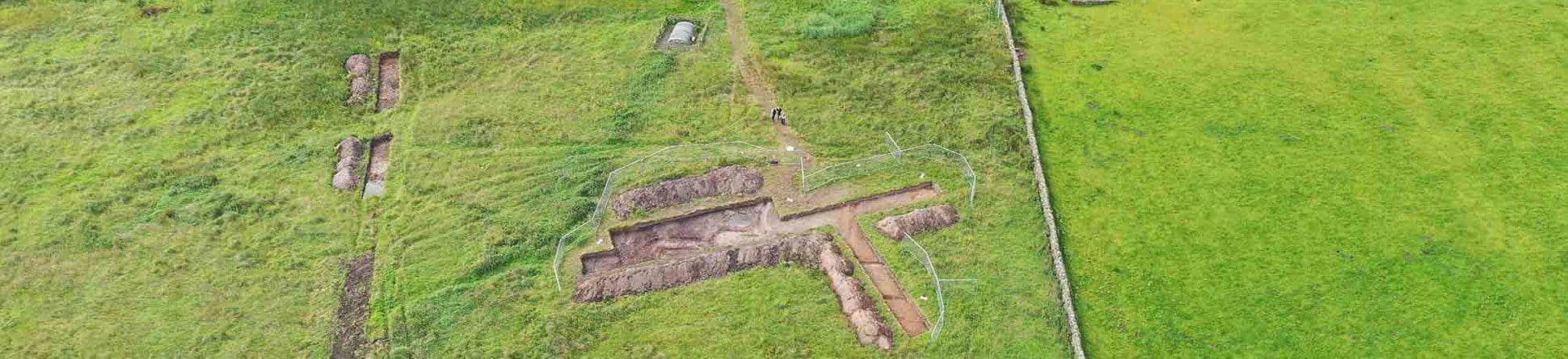 Aerial view of excavations with buildings in the background