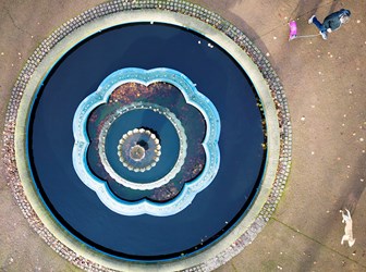 Aerial view of a large round ornamental fountain.