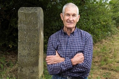 Nigel Ford standing next to a milestone
