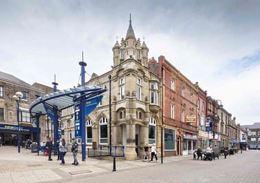 The former Yorkshire Penny Bank with its distinctive corner turret is located in the centre of the image, its neighbour to the right is the former Market Tavern, while on the far right the brick buildings were rebuilt as the White Lion Hotel. 