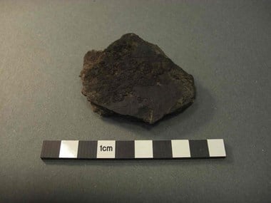 Photograph showing a ceramic sherd with some surviving carbonised residue adhering to its interior surface.