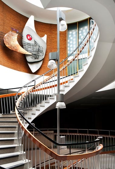 Spiral staircase with a sculpture on the wall