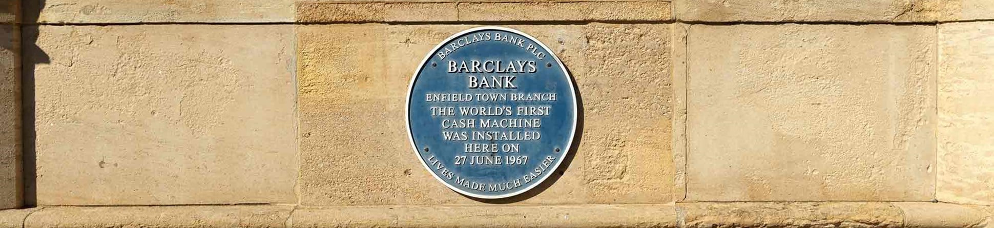 Blue plaque mounted on a stone wall. It reads Barclays Bank, Enfield Town Branch, the world's first cash machine was installed here on 27 June 1967. Lives made much easier.
