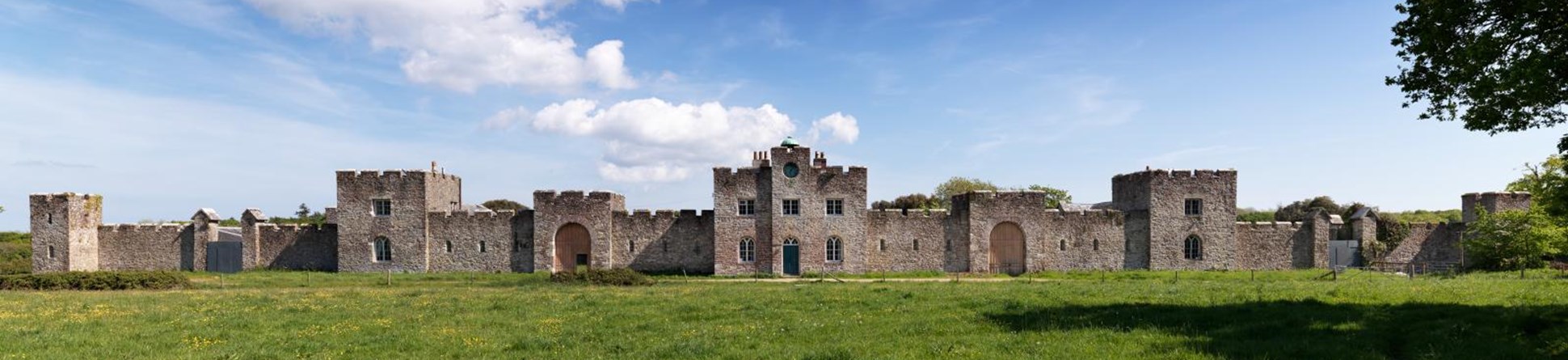 A large castle, with crenelated walls and towers.