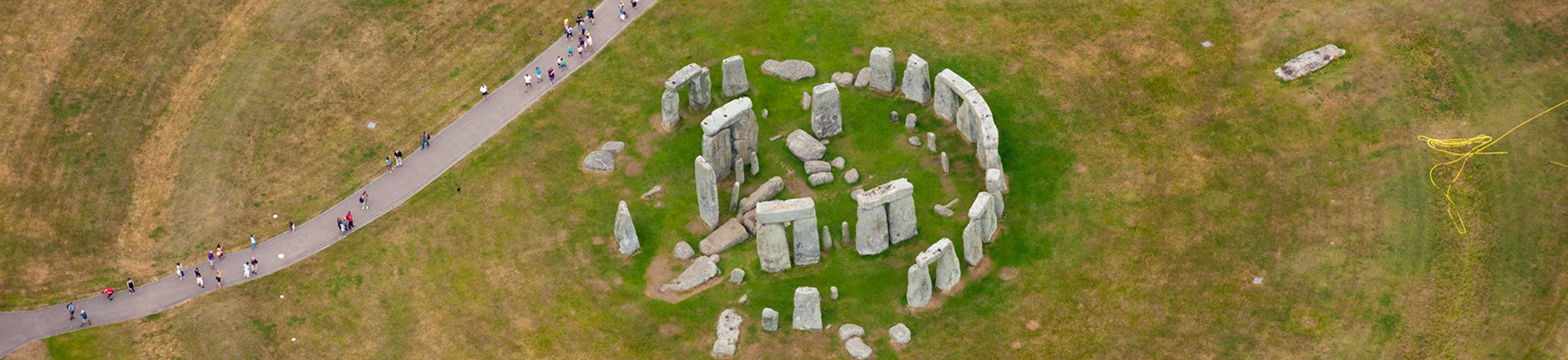 An aerial view of the rocks of Stonehenge. Visitors walking round are tiny in comparison.