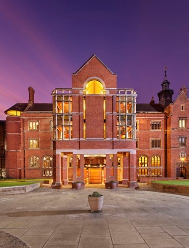 Exterior view from the south-east of St John's College Library, showing the building illuminated at dusk