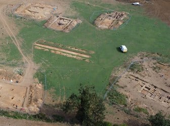 An aerial view of part of an archaeological site, in the bottom right foundations of buildings are visible.