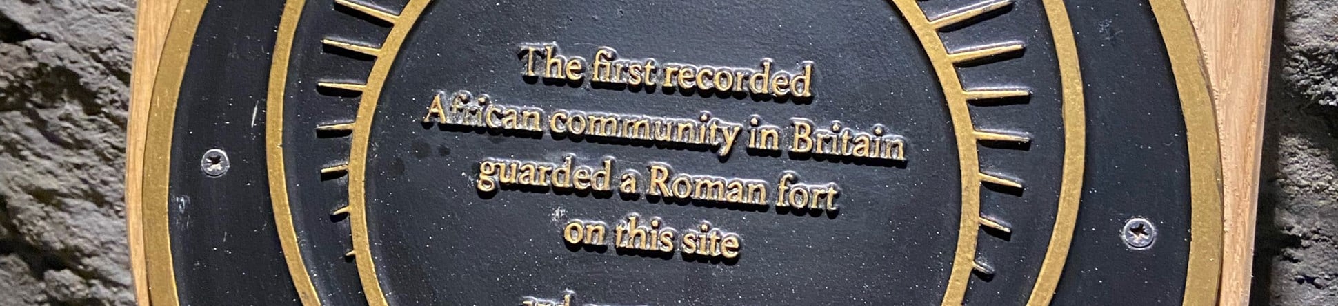 Detail of a plaque, which reads: T'he first recorded African community in Britain guarded a Roman fort on this site 3rd century AD'.