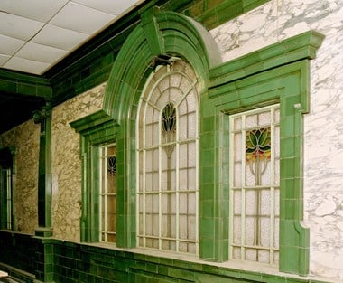 A three-part window with a green glazed frame.