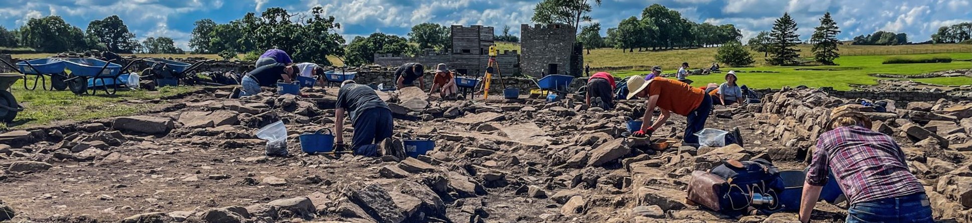 People on their knees digging at an archaeological site.