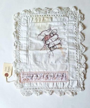 A hand embroidered on a piece of cloth.