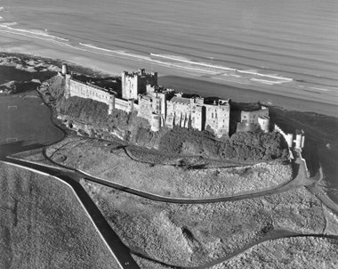 Overhead view of a castle with the sea in the background.