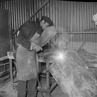 A worker welding in a workshop
