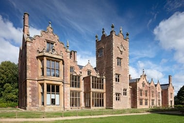 A medium-sized red brick stately home with modern windows and clean repointing.