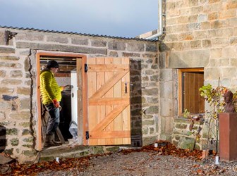 An engineer adjusts controls on a new carbon-friendly technology in a historic stone-built outbuilding. 