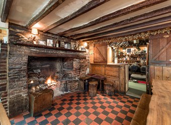 Pub interior, showing bar, tiled floor and fireplace. 