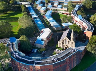 Exterior, drone image from east showing church, snaking estate buildings, Newcastle city centre and Gateshead Millenium Bridge with River Tyne.